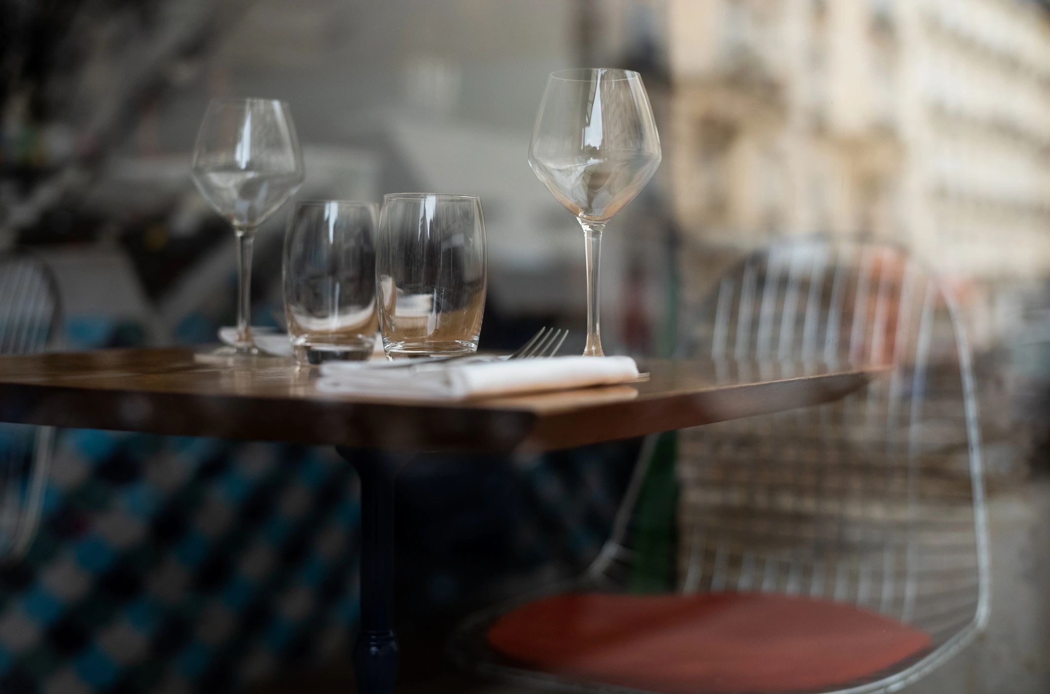 View through a restaurant window showing glassware and warm interior light