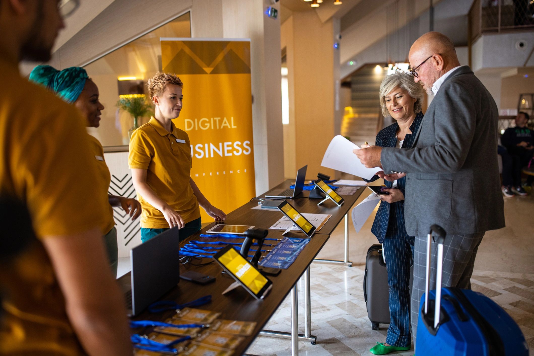 Event registration desk staff assisting guests